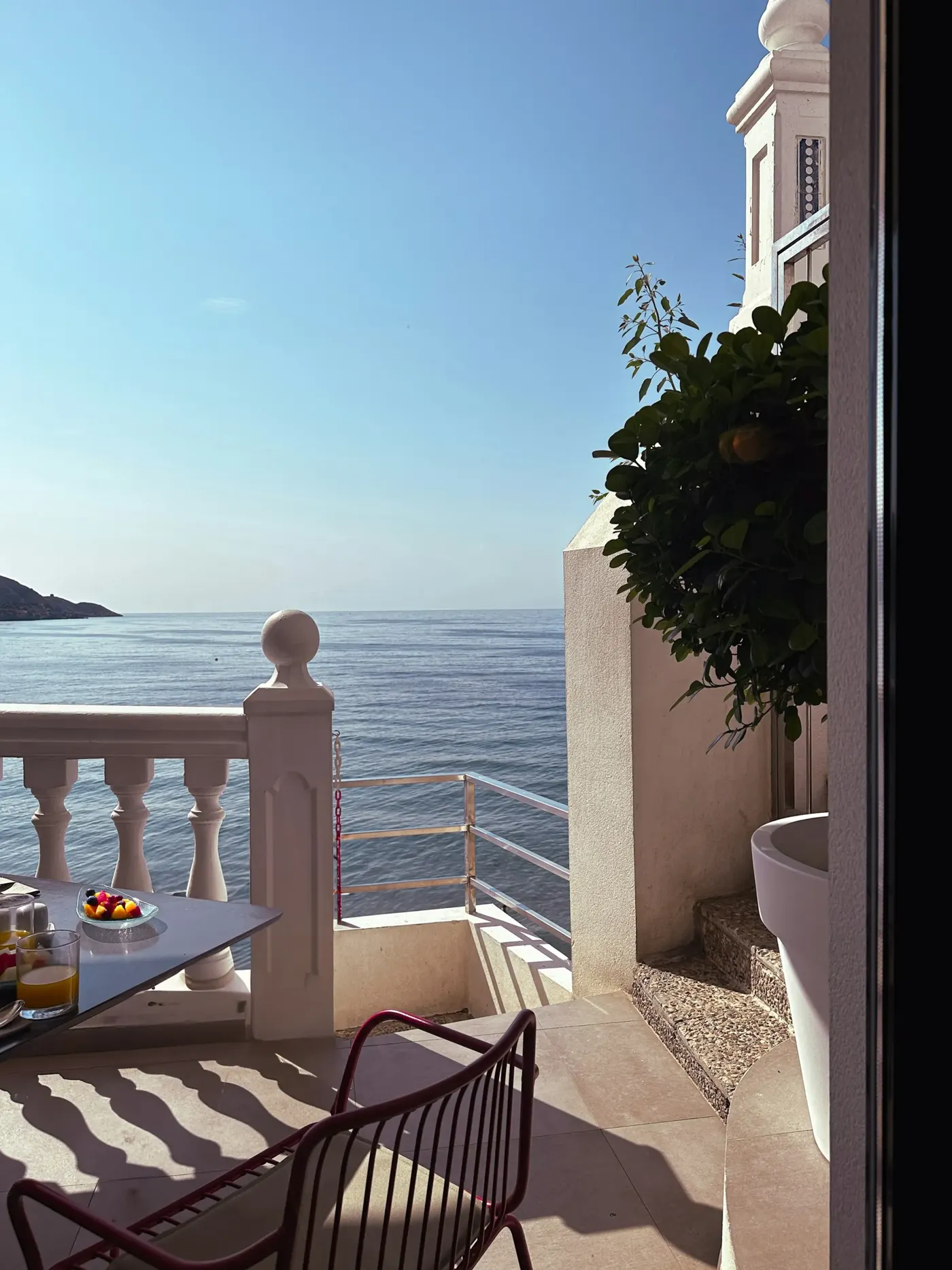Un balcon avec table et chaises face à la mer